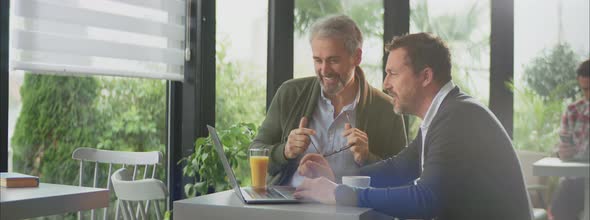 Two smiling gentlemen discussing