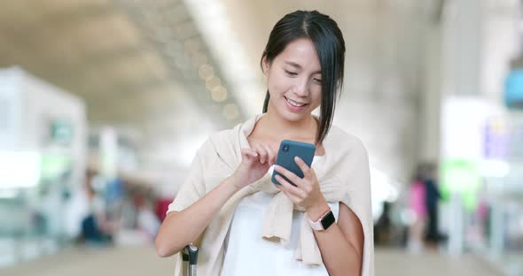 Woman checking on cellphone in the airport