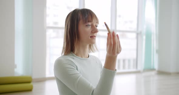 Woman Meditating with Palo Santo Holy Wood Relaxation Zen Practice in Studio