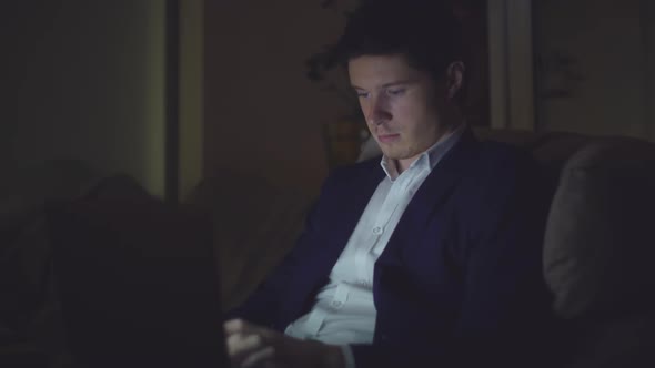 Portrait Man Using Laptop at Nighttime