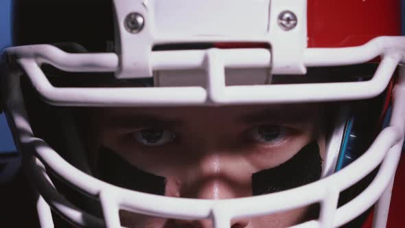 Close Up Portrait of Determined Professional American Football Player in Helmet in Bright Stadium