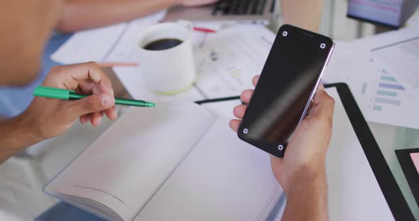 Hands of african american man working, holding smartphone with copy space