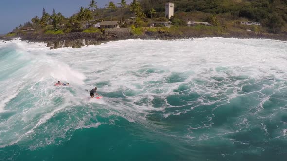 Aerial view of a man sup stand-up paddleboard surfing in Hawaii.