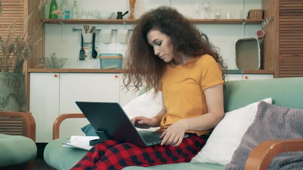 One Girls Works on Laptop, Sitting on a Couch. Remote Learning Concept.