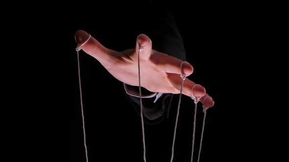 Hand of Dictator in a Business Suit with Strings on the Fingers To Control the Puppet