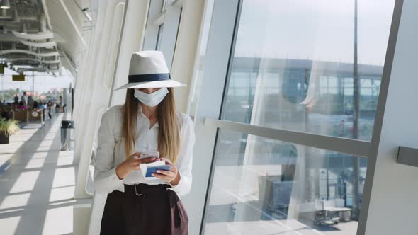 Beautiful Business Woman at the Airport Using the Phone to Send Text Messages