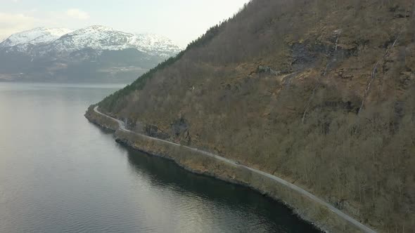 Aerial View of a Road at the Base of a Mountain and Next to a Fjord in Norway