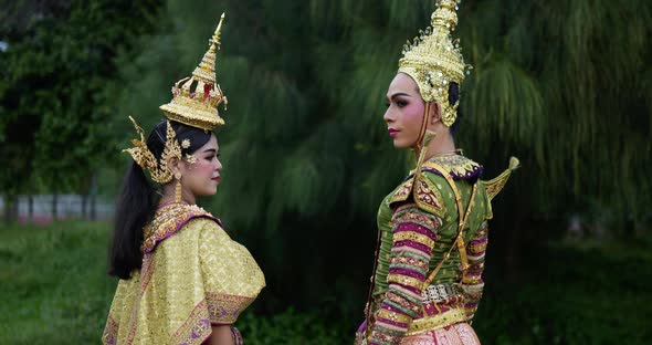 Thai woman and man in traditional dress looking at camera