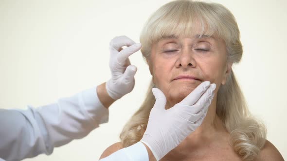 Dermatologist Examining Elderly Female Patient Skin, Wrinkles Removal, Beauty