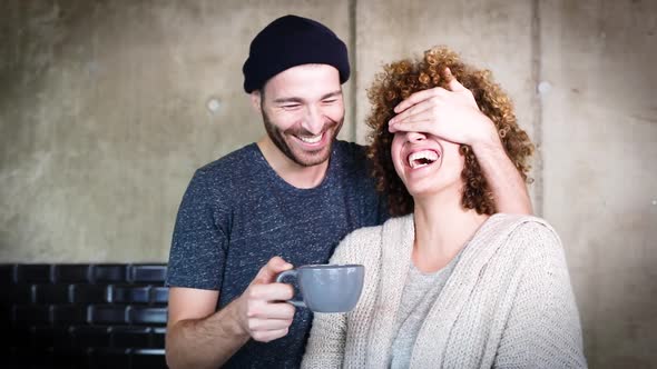 Man covering the eyes of surprised girlfriend