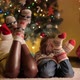 Closeup of Family Feet in Knitted Wool Socks Lying Next to Glowing Christmas Tree in Living Room - VideoHive Item for Sale