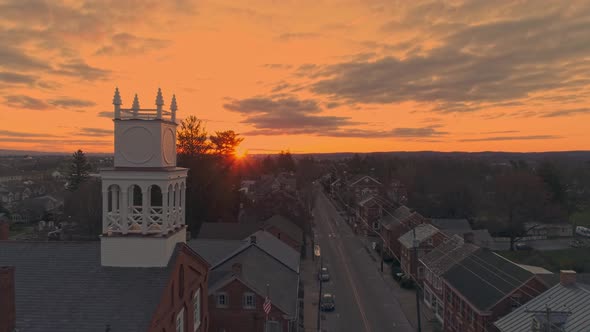 Drone Pull Back View of a Small Town and a Steeple at Sunrise as it gets Ready to Break the Horizon