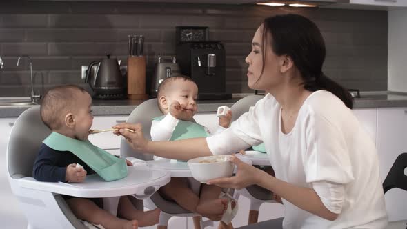 Patient Asian Mom Feeding Stubborn Baby Triplets