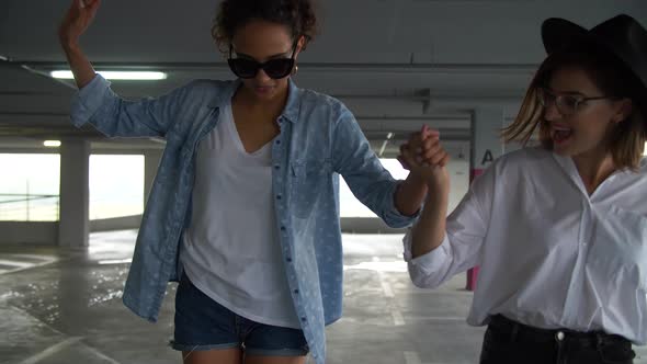 Happy Women Having Fun And Skateboarding At Parking