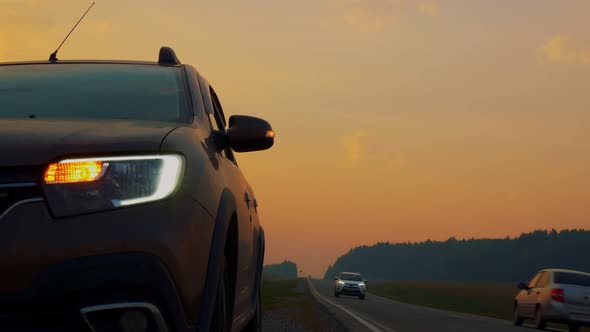 A Car on the Side of the Road with Blinking Emergency Signals Stands on the Side of the Road Along