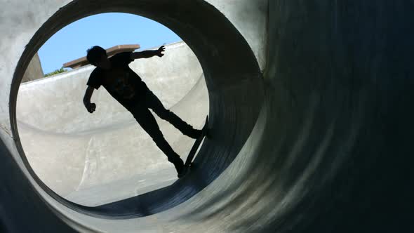 Skateboarder rides a full pipe, slow motion