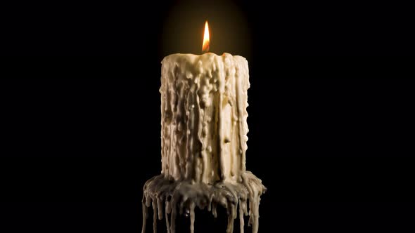 An old and melted candle rotates in front of a black background