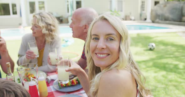 Portrait of happy caucasian woman having dinner with family in garden