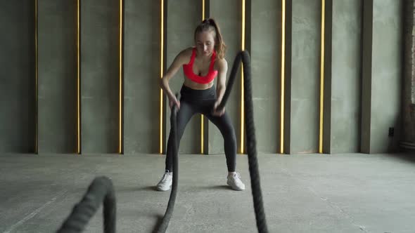 Woman with Battle Ropes Exercise in the Fitness Gym