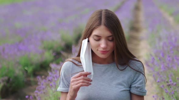 Woman Taking Off Face Mask Outdoors