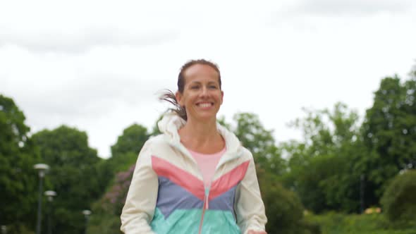 Smiling Woman Running Along Park 