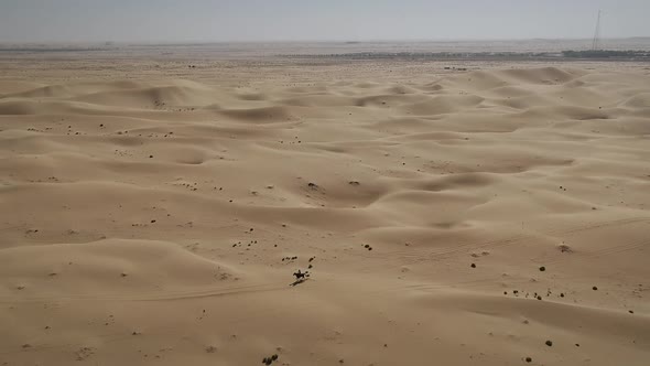 Aerial view of one person riding horse in the desert of Al Khatim in Abu Dhabi.