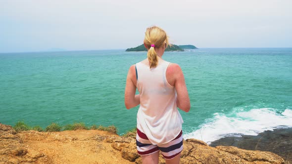 Woman Is Looking at The Sea. Beautiful Seascape with An Island. Waves Beat Against the Rocks