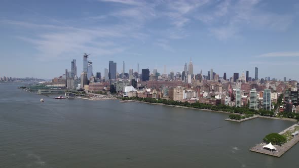 Aerial view of a helicopter flying over the Hudson river in front of the Midtown Manhattan cityscape