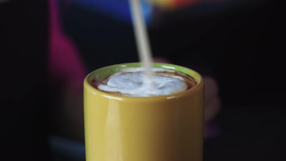 Barista Stirring Sugar in a Cup of Coffee with a Stick
