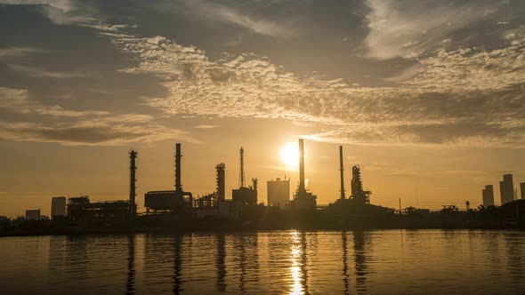 4k timelapse of 4k Oil refinery  petrochemical plant timelapse at sunrise with reflection of river