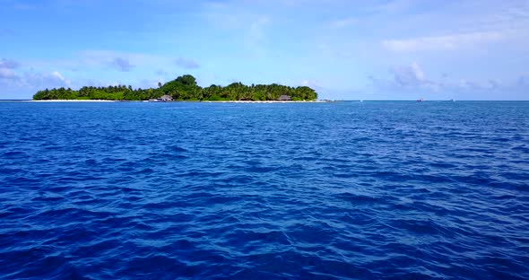 Wide aerial island view of a white sand paradise beach and aqua turquoise water background in colour