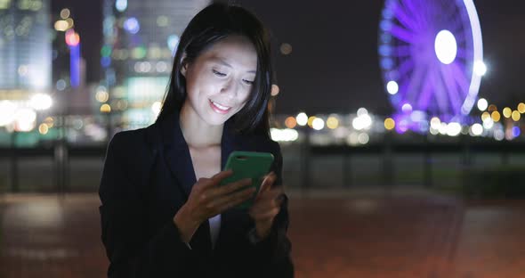 Business woman use of mobile phone at night 