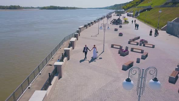 Happy Couple Walks Along Modern Waterfront Bird Eye View