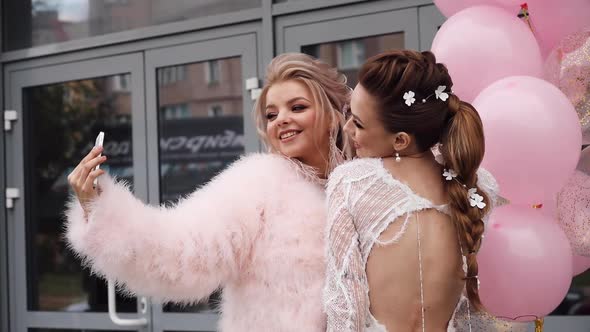 Two Girlfriends Taking Selfies with Air Balloons