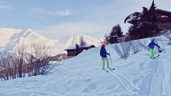 Mother with Child Go Downhill Ski in to the Hotel at Mountains