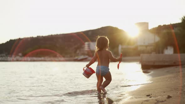 Slow Motion Video of a Little Girl Running on the Beach at Sunset