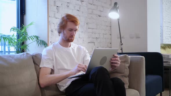 Casual Designer Working with Laptop in His Lap Beard