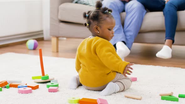 African Baby Girl Playing with Toy Blocks at Home