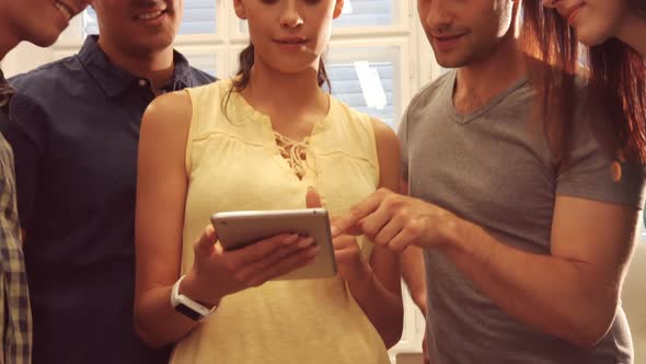 Group of business executives discussing over digital tablet