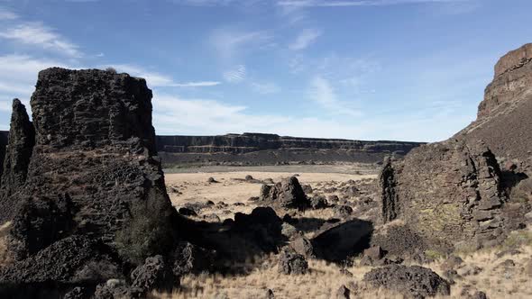 Passing between a towering canyon butte and basalt columns, Dry Falls State Park, aerial