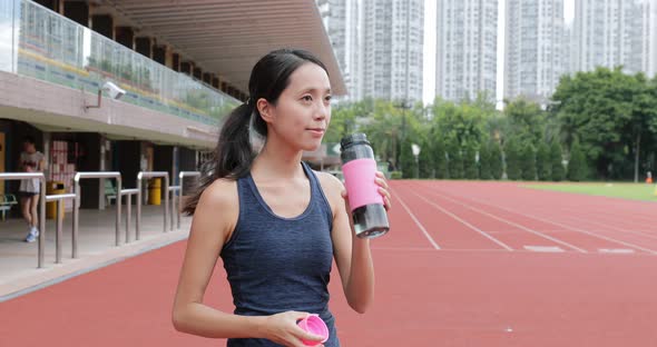 Sport woman drink of water in sport arena 