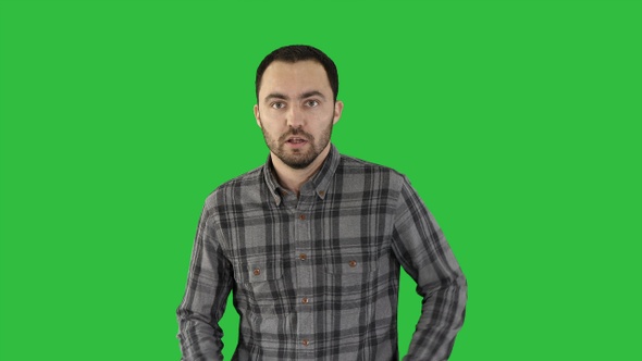 Young man running and smiling on a Green Screen, Chroma Key.