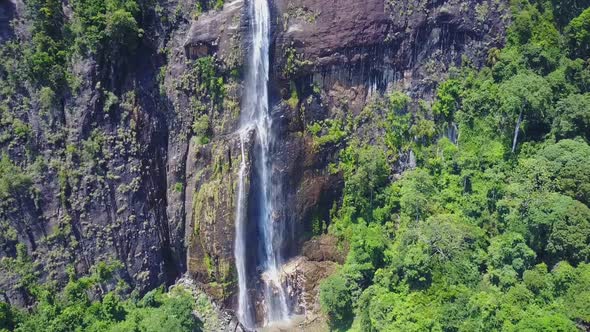 Diyaluma Falls with White Jets on Steep Cliff in Rainforest