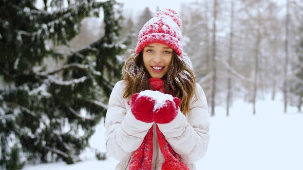 Happy Young Woman Blowing To Snow in Winter Forest 7