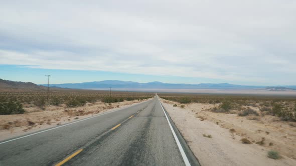 Driving On Asphalt Highway Road Passing Through Arid Desert Valley Of Death