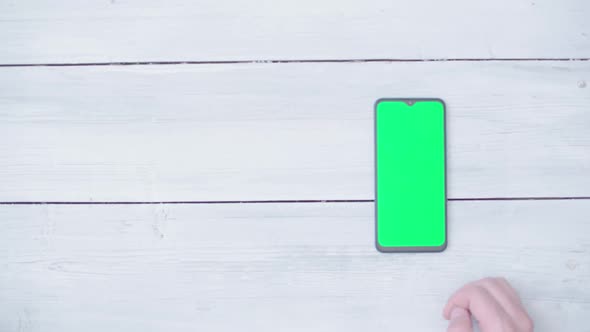 Male Hands with a Smartphone with a Chroma Key on the Table