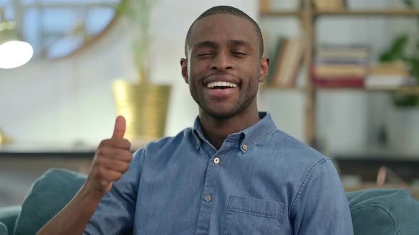 Young African Man with Thumbs Up at Home