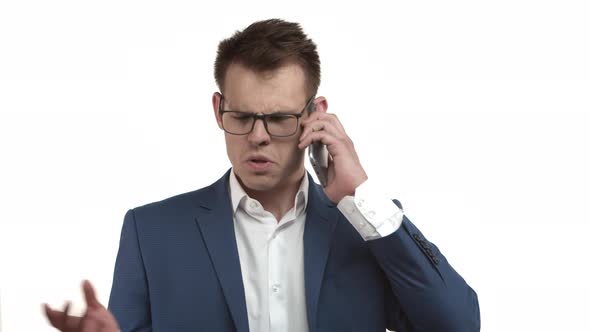 Handsome Arrogant Businessman in Glasses and Blue Suit Picking Up Phone Giving Instructions to