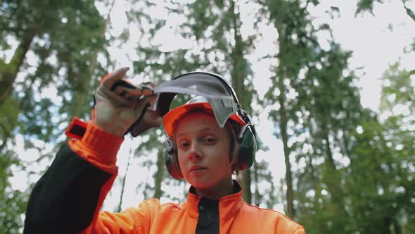 Portrait of a Woman Logger Standing in the Forest Female Specialist in Protective Gear Opens the