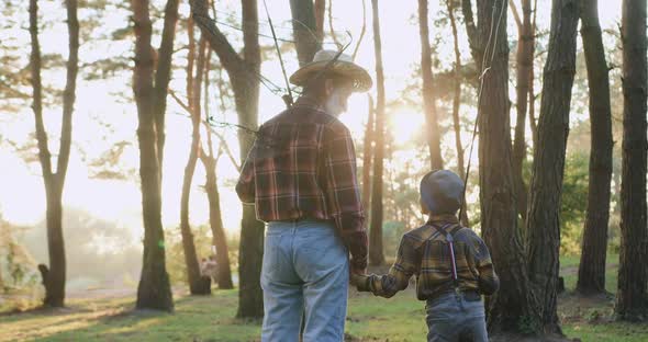 Grandpa Doing Stop in the Park when Going Fishing Together with His 10-Aged Interested Grandson